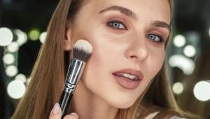 woman holding brush looking mirr Економічні новини - головні новини України та світу