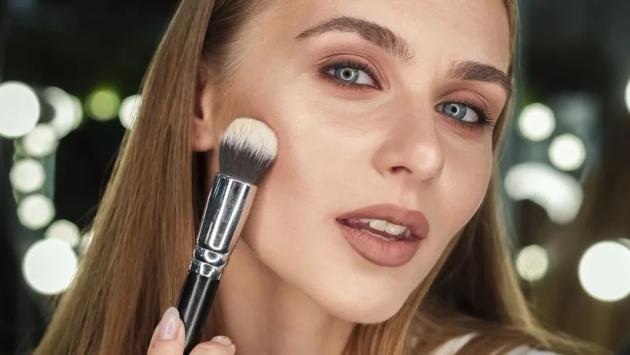 woman holding brush looking mirr Економічні новини - головні новини України та світу