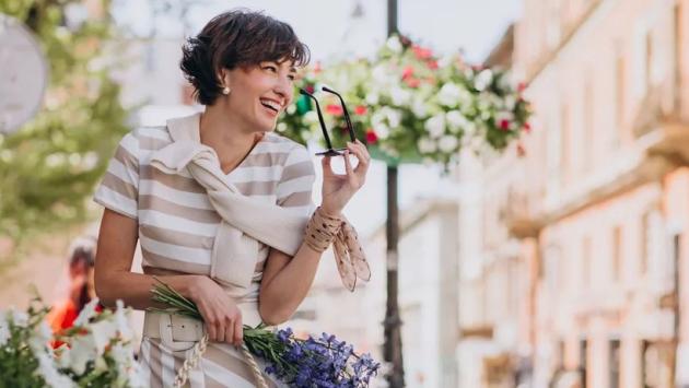 young woman with flowers walking Економічні новини - головні новини України та світу