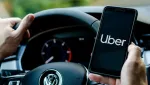 uber driver holds smartphone in car Економічні новини - головні новини України та світу