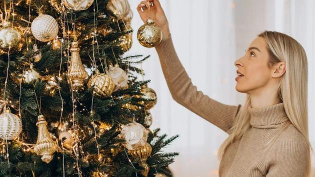 woman decorating christmas tree Економічні новини - головні новини України та світу